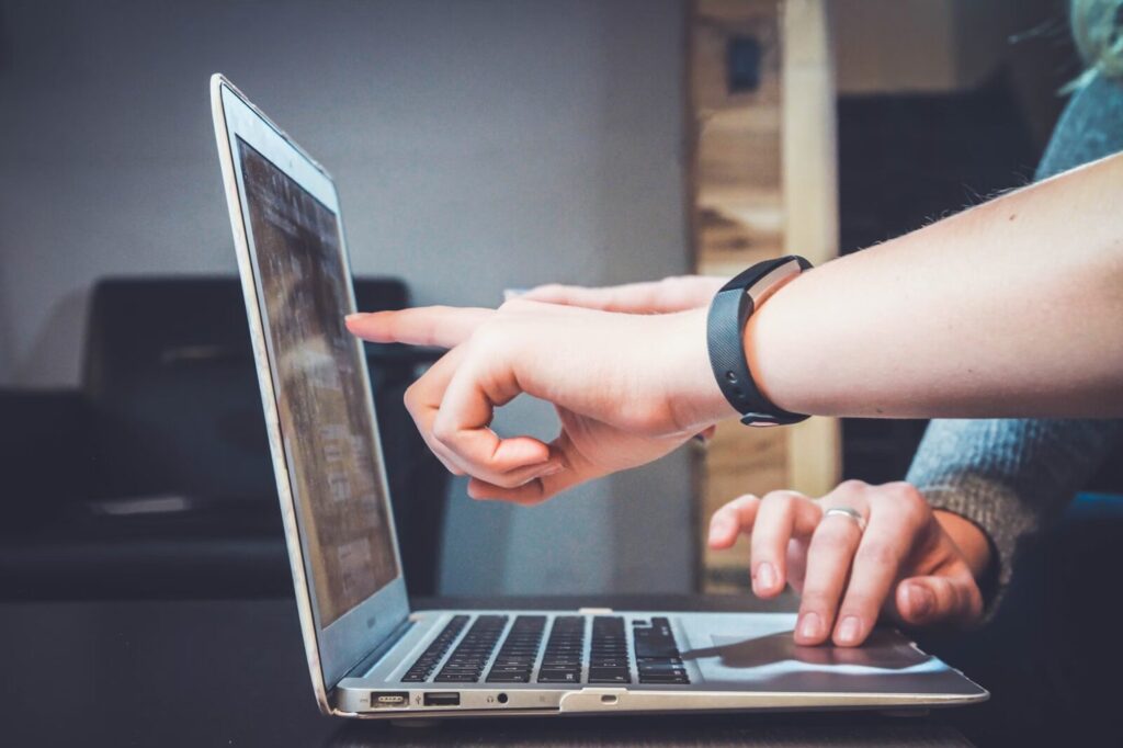 person pointing at lap top screen